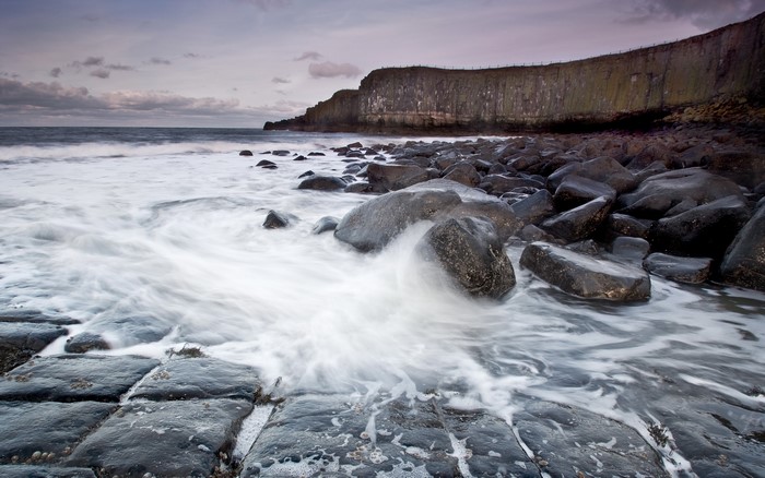 Rocky coastline with waves crashing on stones