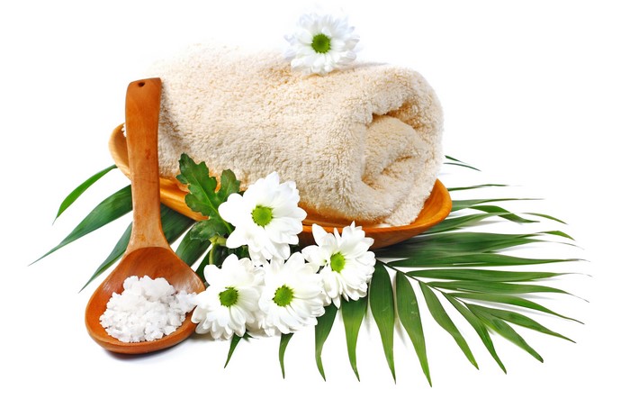 Spa towel with flowers and salt on a wooden spoon