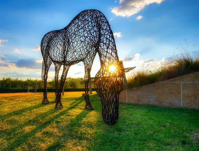 Wireframe horse sculpture at sunset