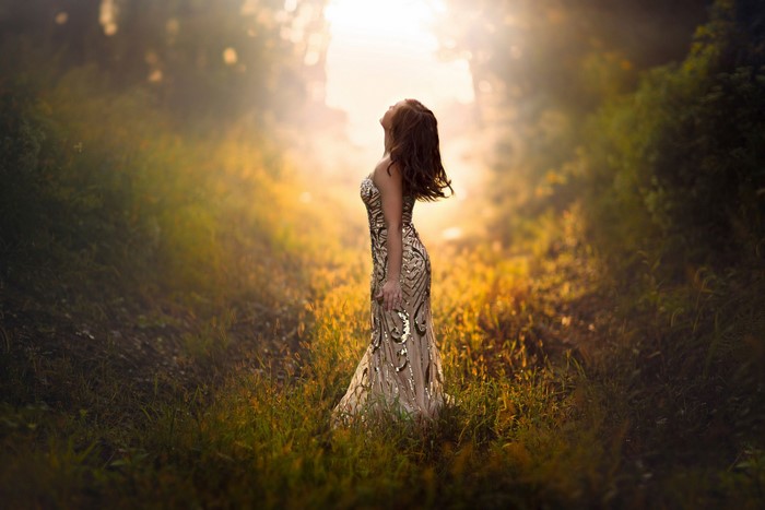 Woman in a sparkly dress in a foggy forest