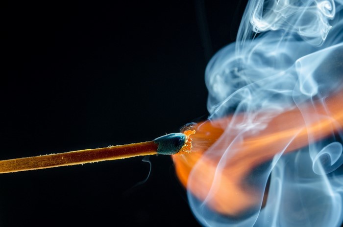 Close-up of a burning match with smoke