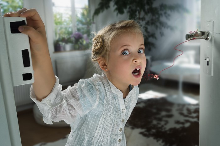 Girl losing a tooth at a door handle