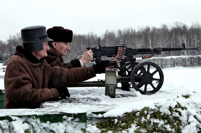 Two elderly men with a SG-43 Goryunov machine gun in winter