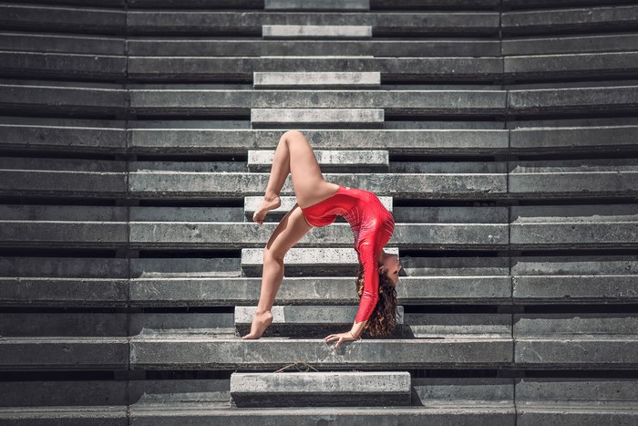 Mira Boumejmajen performing gymnastics on concrete stairs