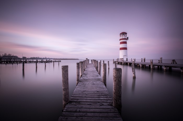 Lighthouse on a pier at sunset