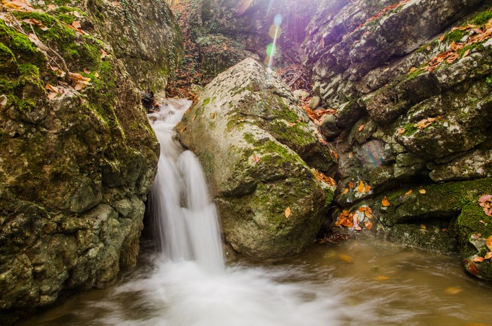 Waterfall flowing over mossy rocks in a forest