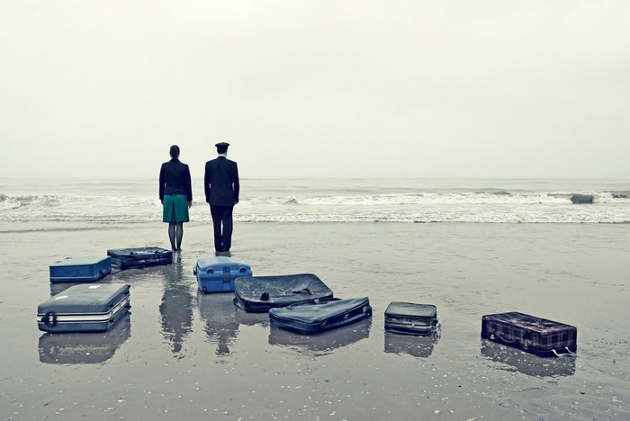 Two people and suitcases on a beach