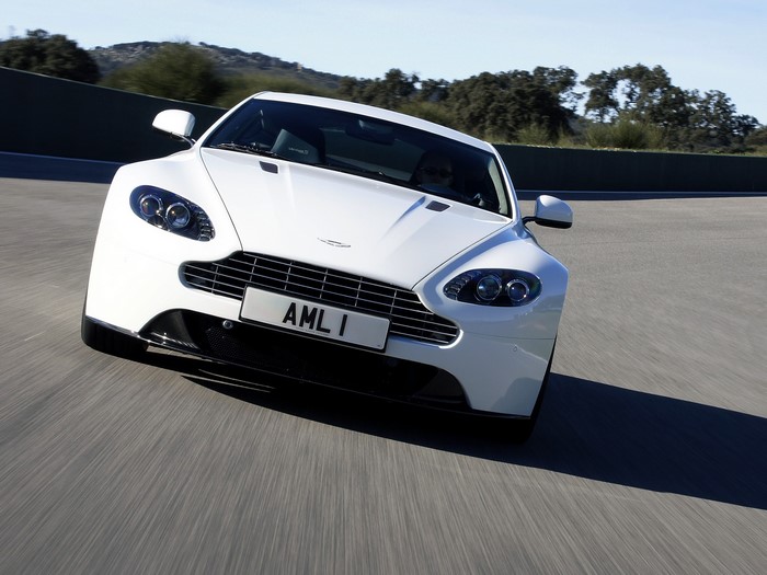 White Aston Martin V8 Vantage S driving on a track