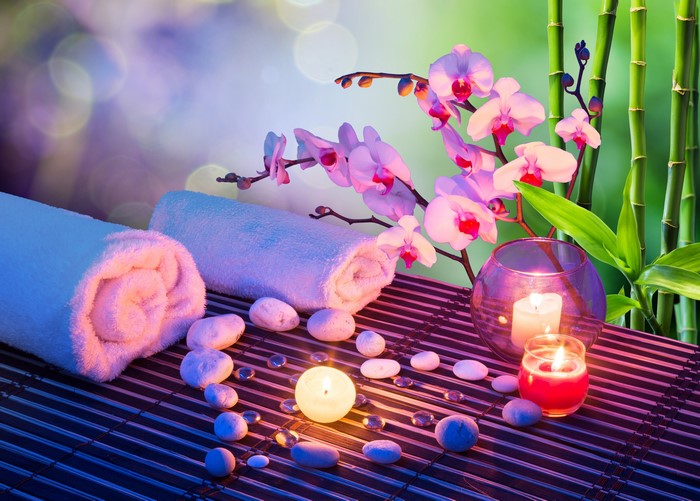 Spa setting with orchids, candles, stones, and towels