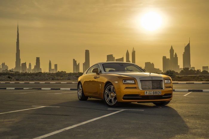 Gold Rolls-Royce Wraith in Dubai Cityscape at Sunset