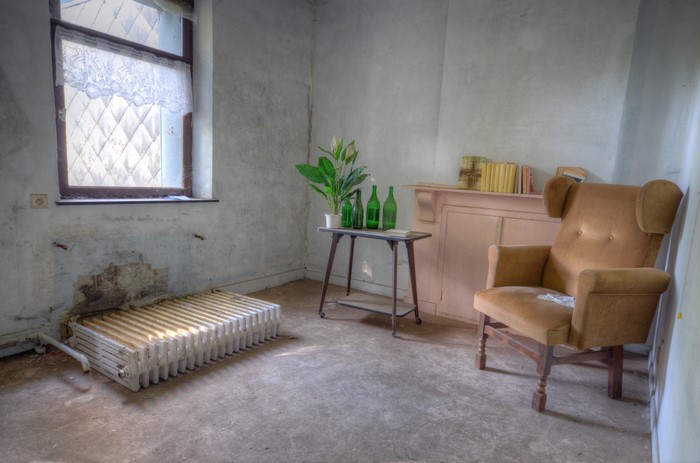Abandoned room with armchair and radiator