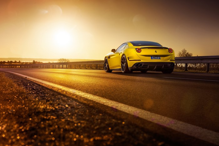 Yellow Ferrari California T on a Road at Sunset