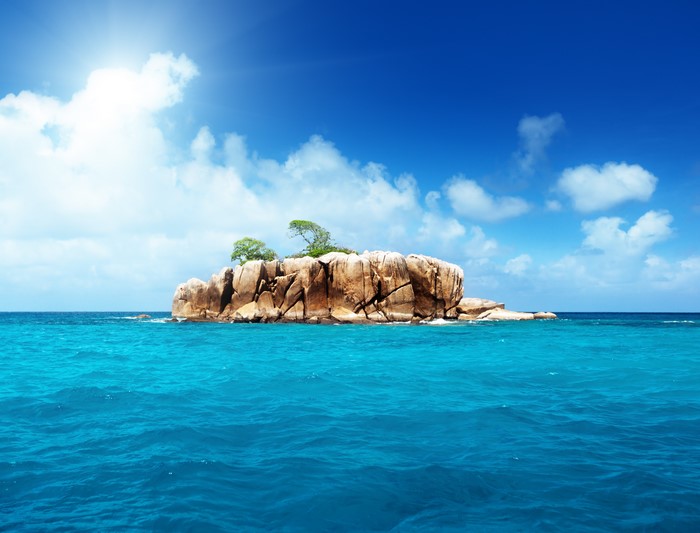 Island Crag in Tropical Sea with Clouds