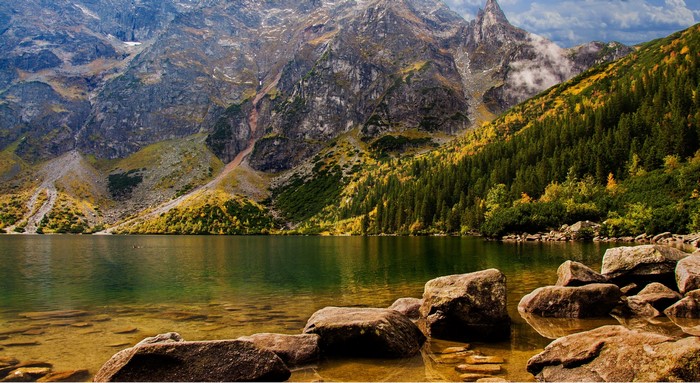 Lake and mountains with autumn trees and rocks