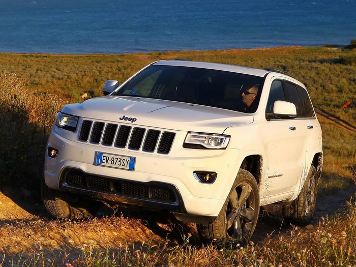 White Jeep Grand Cherokee Overland driving off-road