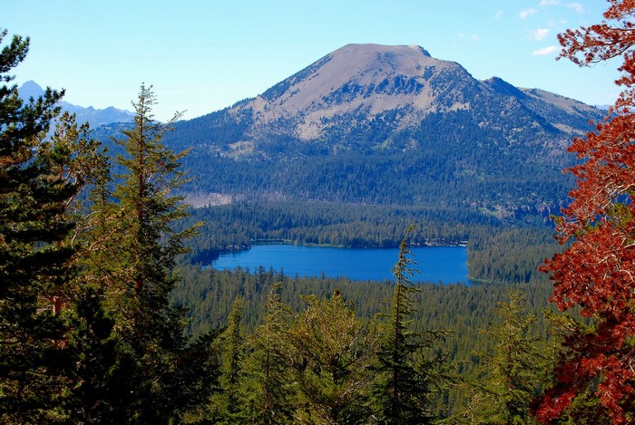 Mountain lake surrounded by pine forests and autumn trees