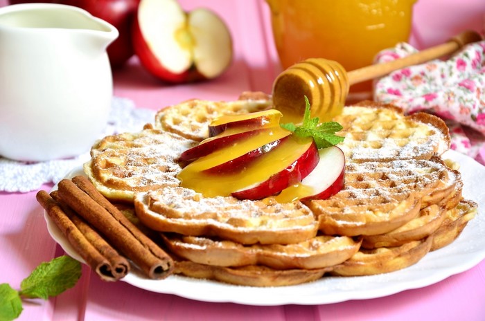 Waffles with apples, honey, and cinnamon sticks