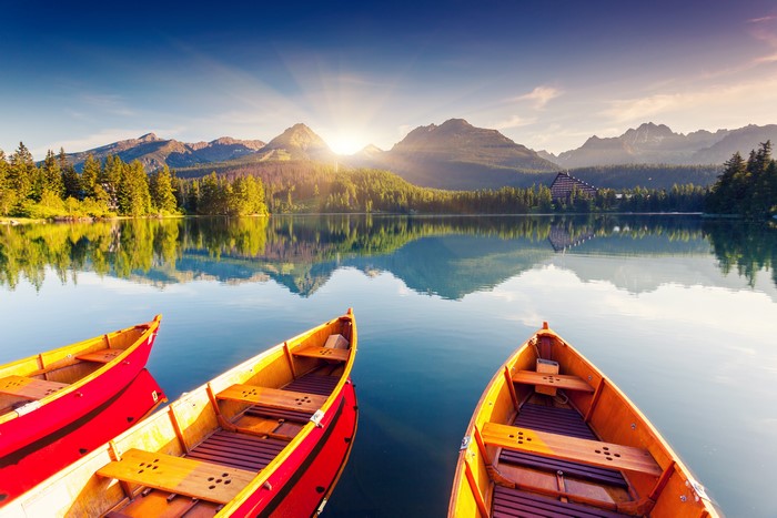 Boats on a lake with mountains at sunrise