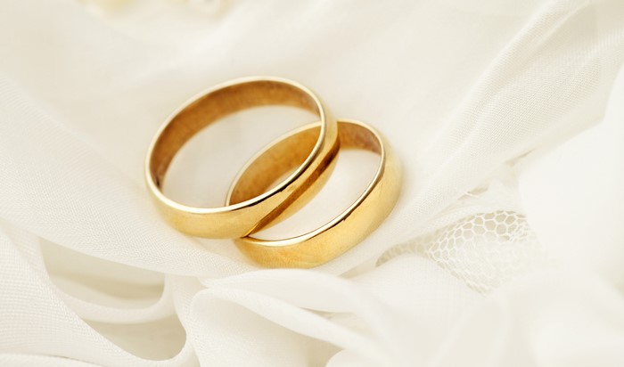 Two gold wedding rings on white fabric