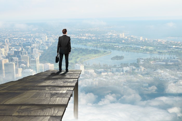 Man in suit on wooden platform overlooking city