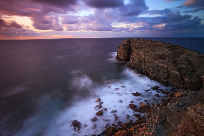 Rocky coast with waves crashing at sunset