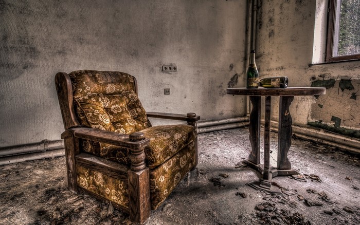 Abandoned room with armchair and table