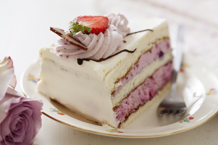 Slice of layered cake with strawberry and cream