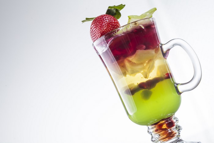 Cocktail with strawberry and fruits in a highball glass