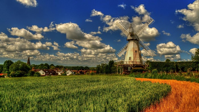 Windmill in Woodchurch, Kent, England with fields and village