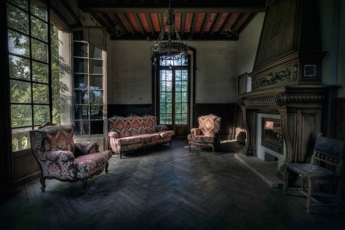 Abandoned room with antique furniture and fireplace