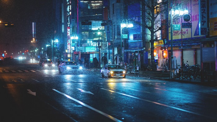 Datsun driving on a rainy street at night in Japan
