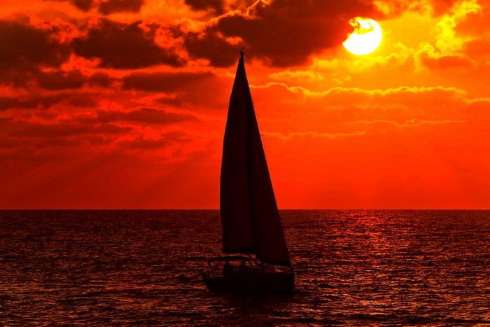 Sailboat on the ocean at sunset