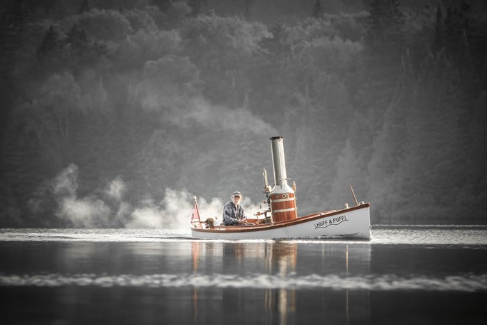 Man on a steam-powered boat named Huff & Puff