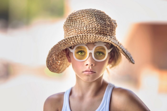 Girl wearing a straw hat and novelty glasses