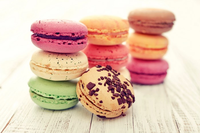 Stack of colorful macarons on a white wooden surface