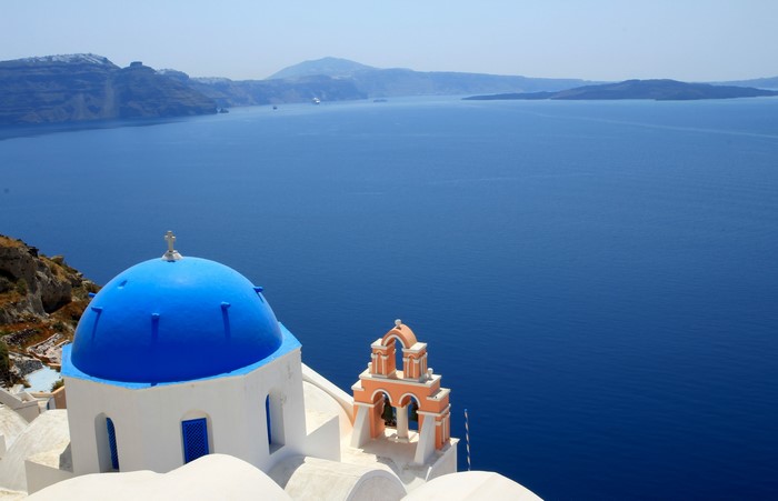 Blue Dome Church and Bell Tower in Oia, Greece overlooking the Sea