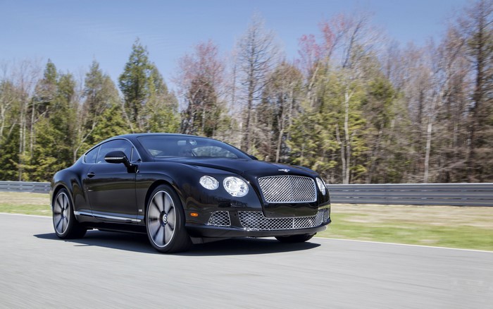 Black Bentley Continental GT driving on a road