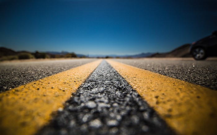 Road with yellow lines and a car