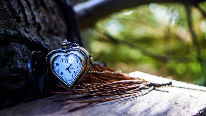 Heart-shaped pocket watch on wood