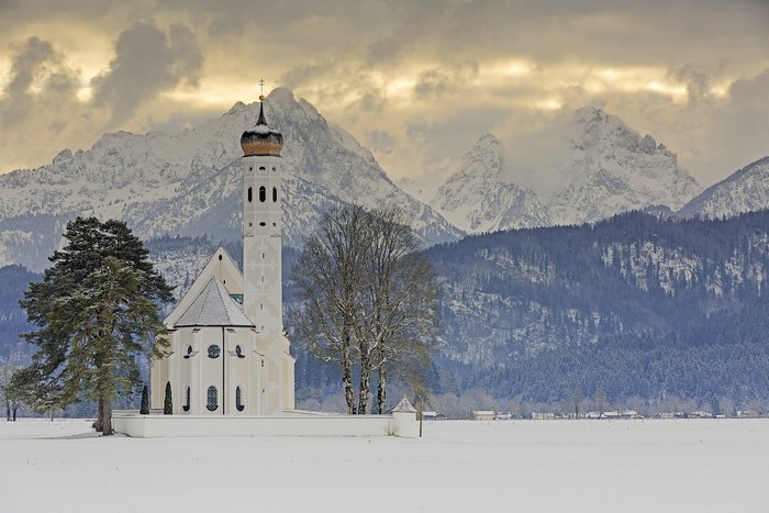 St. Coloman Church in Schwangau, Bavaria, Germany, with Alps in snow
