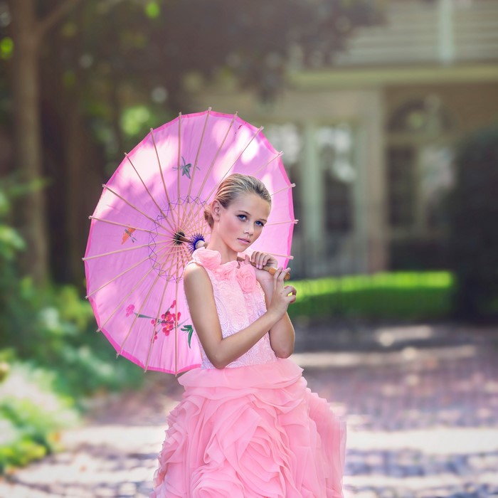 Girl in pink dress with pink umbrella