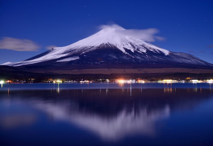 Mount Fuji reflected in a lake at night
