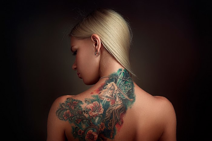 Woman with a large tattoo on her back and neck