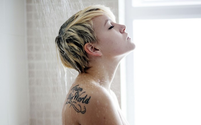 Woman with tattoo showering