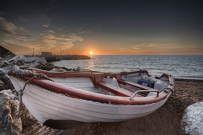 Boat on a rocky shore at sunset