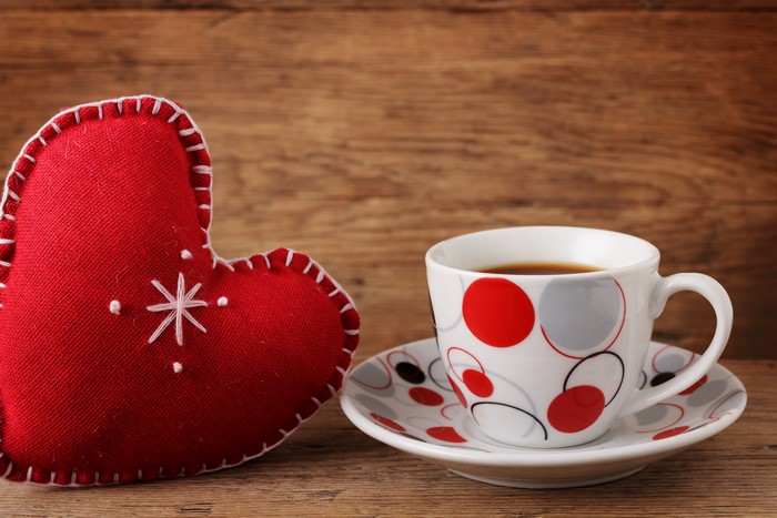 Red Heart Pillow and Coffee Cup on Wooden Table