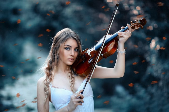 Woman playing violin in autumn