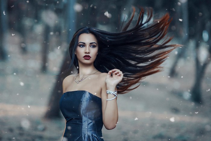 Woman with windblown hair in snowy woods