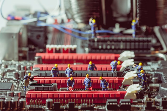 Miniature construction workers on a computer motherboard