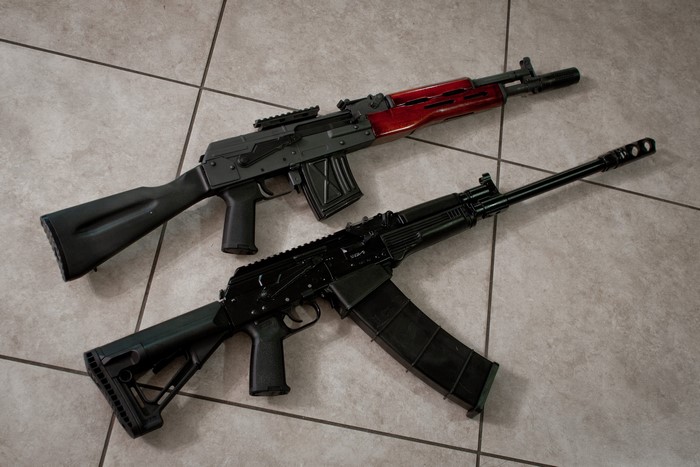 Two Saiga-12 shotguns on tiled floor